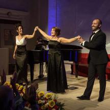a man and woman dancing on a stage with a piano