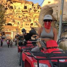 un grup de oameni care merg cu ATV-uri pe o stradă