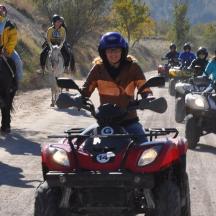 a group of people on atvs and horses on a dirt road
