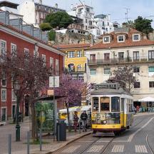 a yellow trolley on a city street with buildings