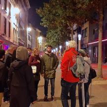a group of people standing on a street at night