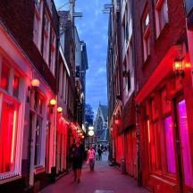 a group of people walking down a street with red lights
