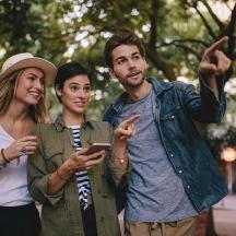a group of three people looking at a cell phone