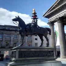 a statue of a man riding a horse with a cone on its head