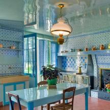 a blue kitchen with a table and a fireplace