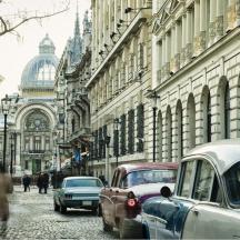 a city street with cars parked on the side of buildings