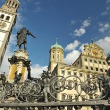 a statue in front of a building with a clock tower