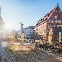 a group of people sitting around a fountain in a city