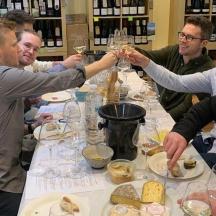 en gruppe mennesker sidder omkring et bord med vinglas