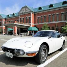 a white car parked in a parking lot in front of a building