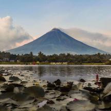 a mountain in the background with a lake with algae