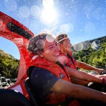 two people riding a boat down a river