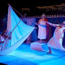 a group of women standing on stage with an umbrella