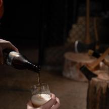 eine Person, die ein Getränk in ein Weinglas gießt