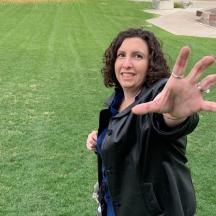 eine Frau, die mit erhobener Hand auf einem Feld steht