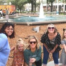 a group of people standing in front of a fountain