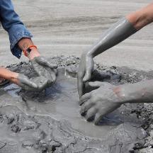 two people playing in a mud puddle
