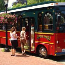 a group of people standing outside of a trolley