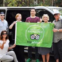 a group of people holding a sign in front of a car