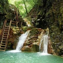 ein Wasserfall mitten in einem Berg mit einer Leiter