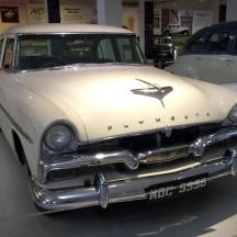 an old white car is parked in a garage