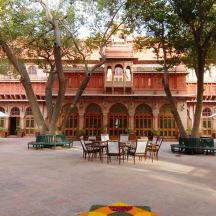 a courtyard with tables and chairs in front of a building