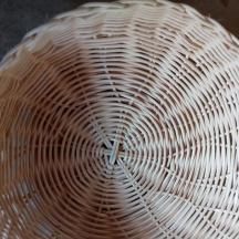 a white wicker bowl sitting on top of a table