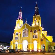 gereja kuning dengan menara jam pada waktu malam