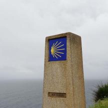 a pillar with a sign on it next to the ocean