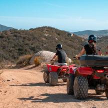 un grup de persones que condueixen quads per un camí de terra