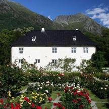 a white house with flowers in front of it