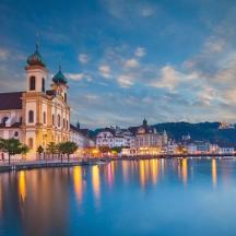 a city with a building and a river at night