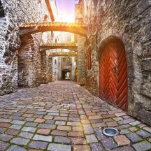 eine Gasse mit einem Steingebäude mit einer roten Tür