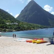 a group of boats on a beach with a mountain
