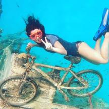 a woman laying on a bike in the water
