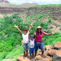 a woman and two children standing on top of a mountain