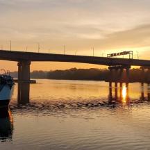 eine Brücke über einen Fluss mit einem Boot im Wasser