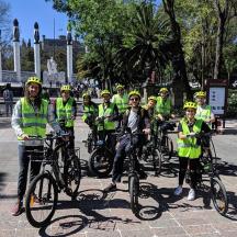 a group of people in yellow vests standing with their bikes