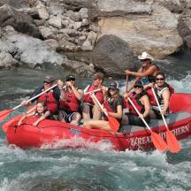 a group of people in a red raft on a river