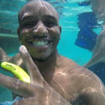 a man in the water holding a yellow frisbee