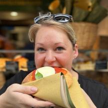 a woman holding a sandwich in her mouth