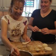 two women standing in a kitchen preparing food