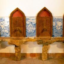 a stone bench with four doors on a wall