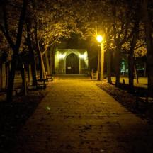a park at night with a light in the distance