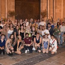 a group of people posing for a picture in front of a building