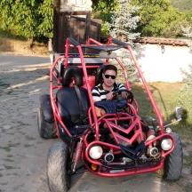 a woman is driving a red trike car