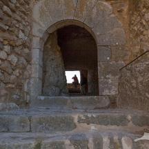 una persona in piedi sotto un arco in un edificio in pietra