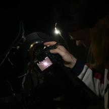 una dona fent una foto amb una càmera a la foscor
