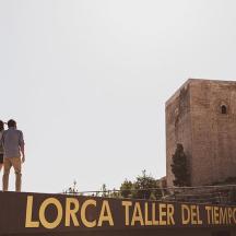 un uomo in piedi in cima a un cartello di fronte a un castello