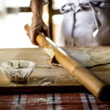una persona che tiene un coltello e una ciotola su un tavolo